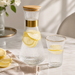 Geriffelte Glasstruktur und goldfarbene Details des Wassersets